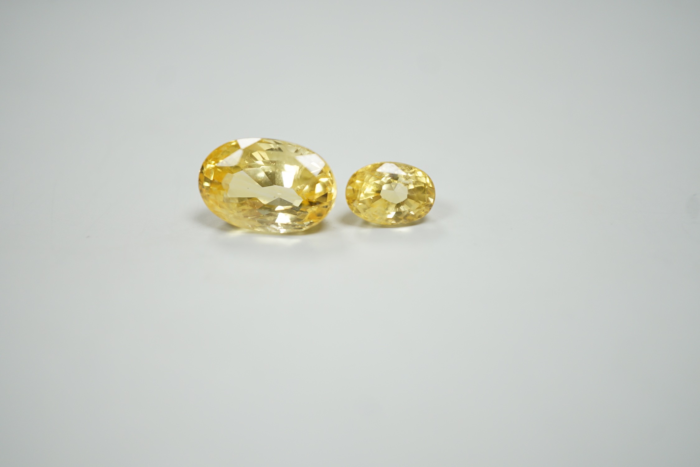 Two oval cut unmounted yellow sapphires, weighing approximately 13.00ct and 4.60ct.